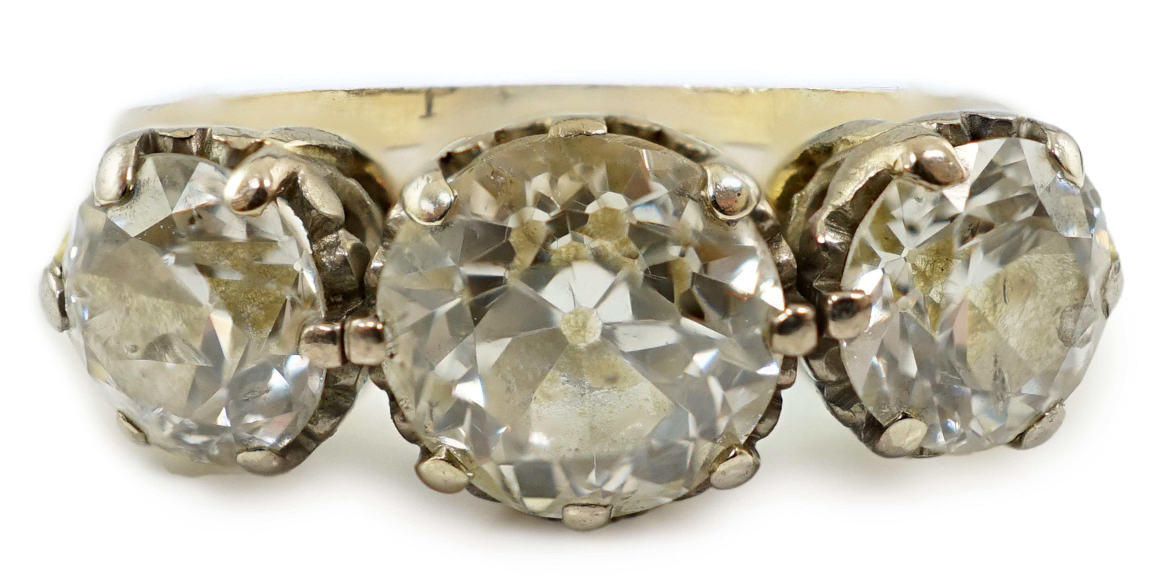 An unmarked gold and three stone diamond set ring